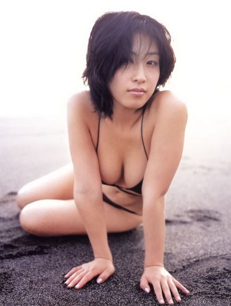 Erotic asian beauty laying around on the beach in her bikini